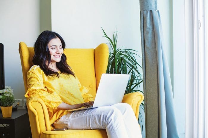 Woman sitting smiling at laptop